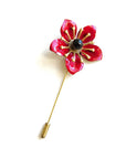 Red poppy lapel pin with enamel petals and black center on brass stem, minimalist floral boutonniere