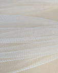 Close-up of soft white English tulle on a beige background
