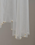 Close-up of hand-applied pearls on soft wedding tulle scarf