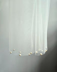 Close-up of hand-applied pearls on soft wedding tulle scarf