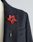 POPPY red enamel pin with black center worn on black lapel mens statement boutonniere