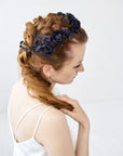 View of a bride with a complex braid hairstyle featuring the FIONA black silk velvet rose crown, showing the flexible integration of hand-sculpted flowers.