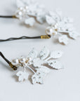 Close-up of frosted leaf bridal hair pin with pearls and rhinestones