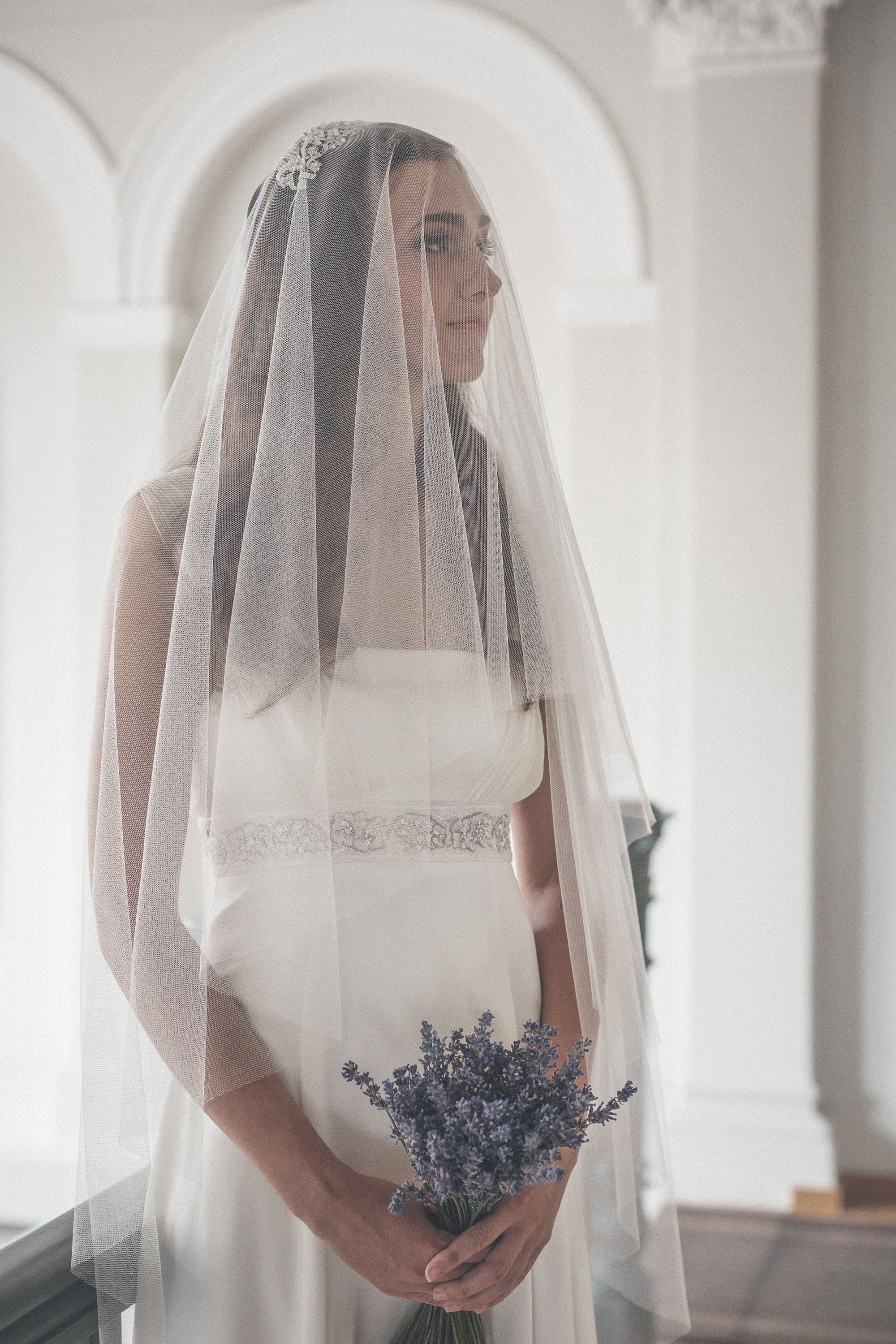 Single-tier wedding veil floating over bride, English tulle