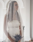 Single-tier wedding veil floating over bride, English tulle