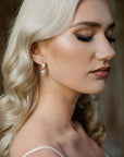 Bride wearing PERELLA pearl and crystal drop earrings with bridal gown