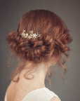 Gold leaf bridal hair comb worn in low bun hairstyle