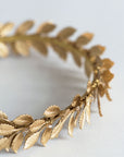 Gold metal laurel leaves with crystal details on a Roman-style bridal headband