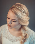 Carpo gold oak leaf bridal headband with pearls shown on a bride with a textured blonde side braid.