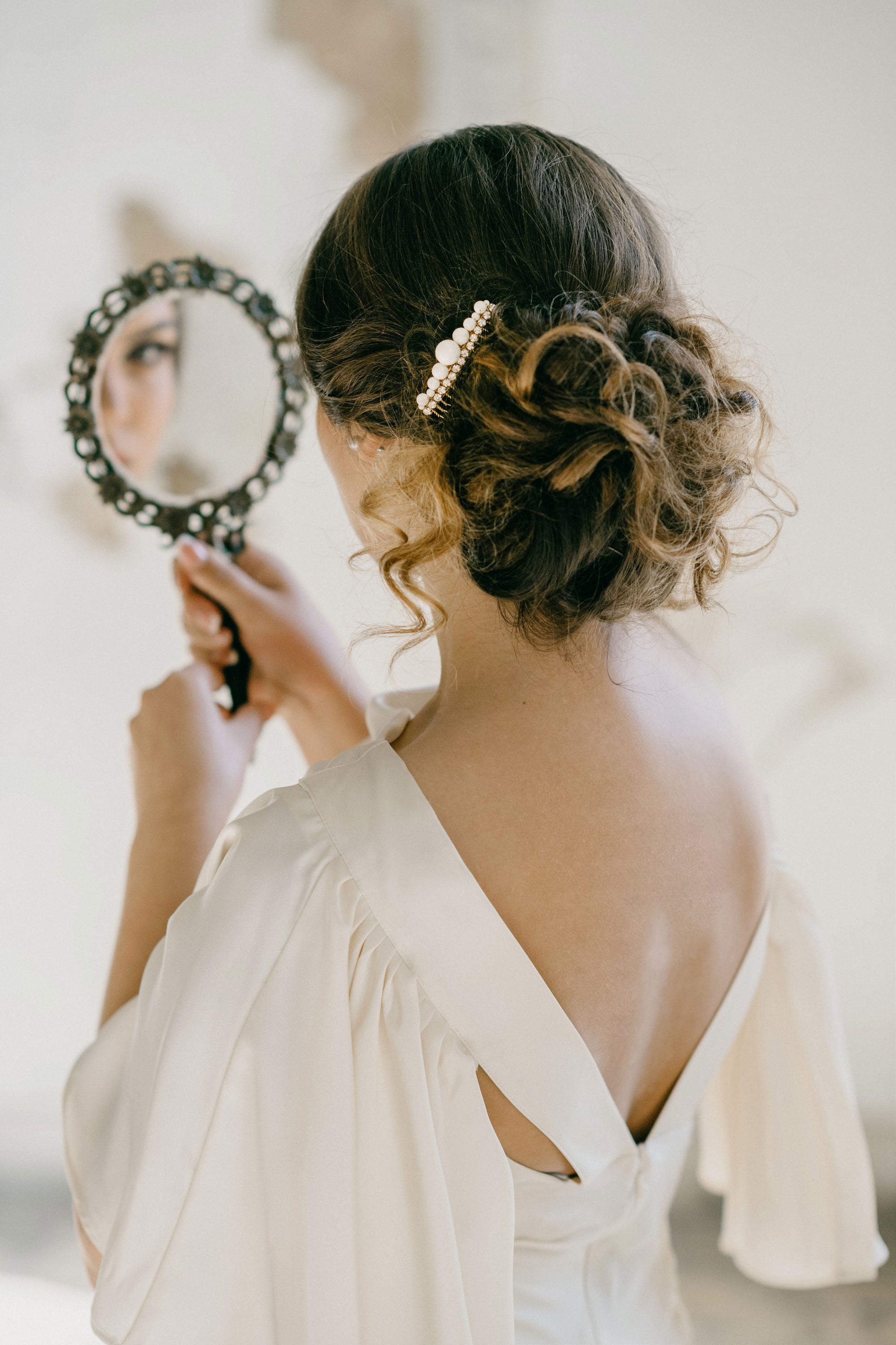 Handcrafted pearl and crystal bridal hair comb in gold finish for wedding updos.