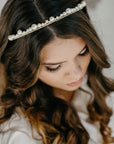 Model wearing ERDME pearl and crystal tiara in ivory cream with gold headband