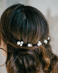 Bride wearing pearl hair pins in updo, minimalist bridal hairstyle with ALSA pins