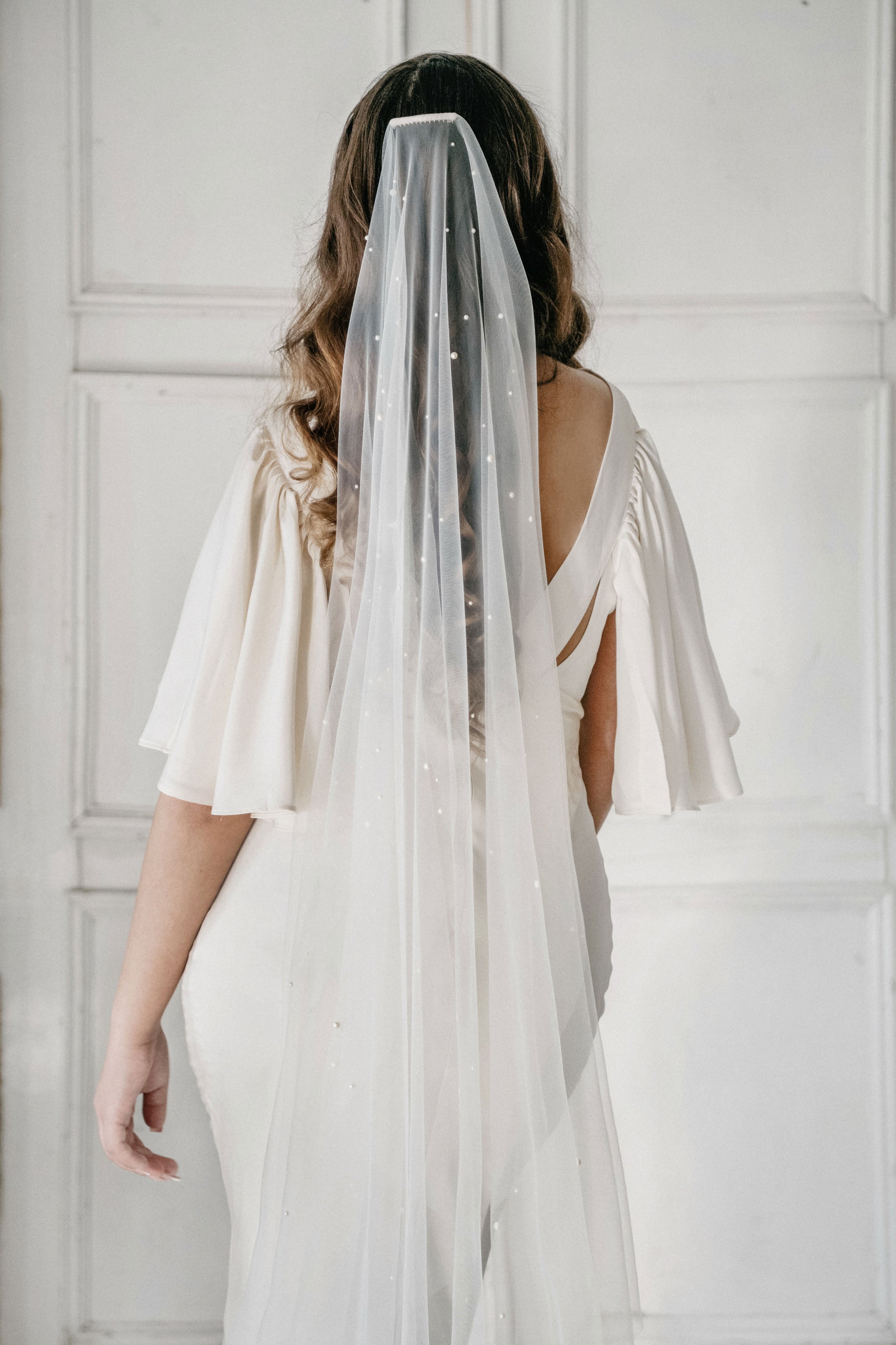 Bride wearing AUGUSTE pearl wedding veil with scattered pearls on soft Italian tulle, modern one-tier bridal look