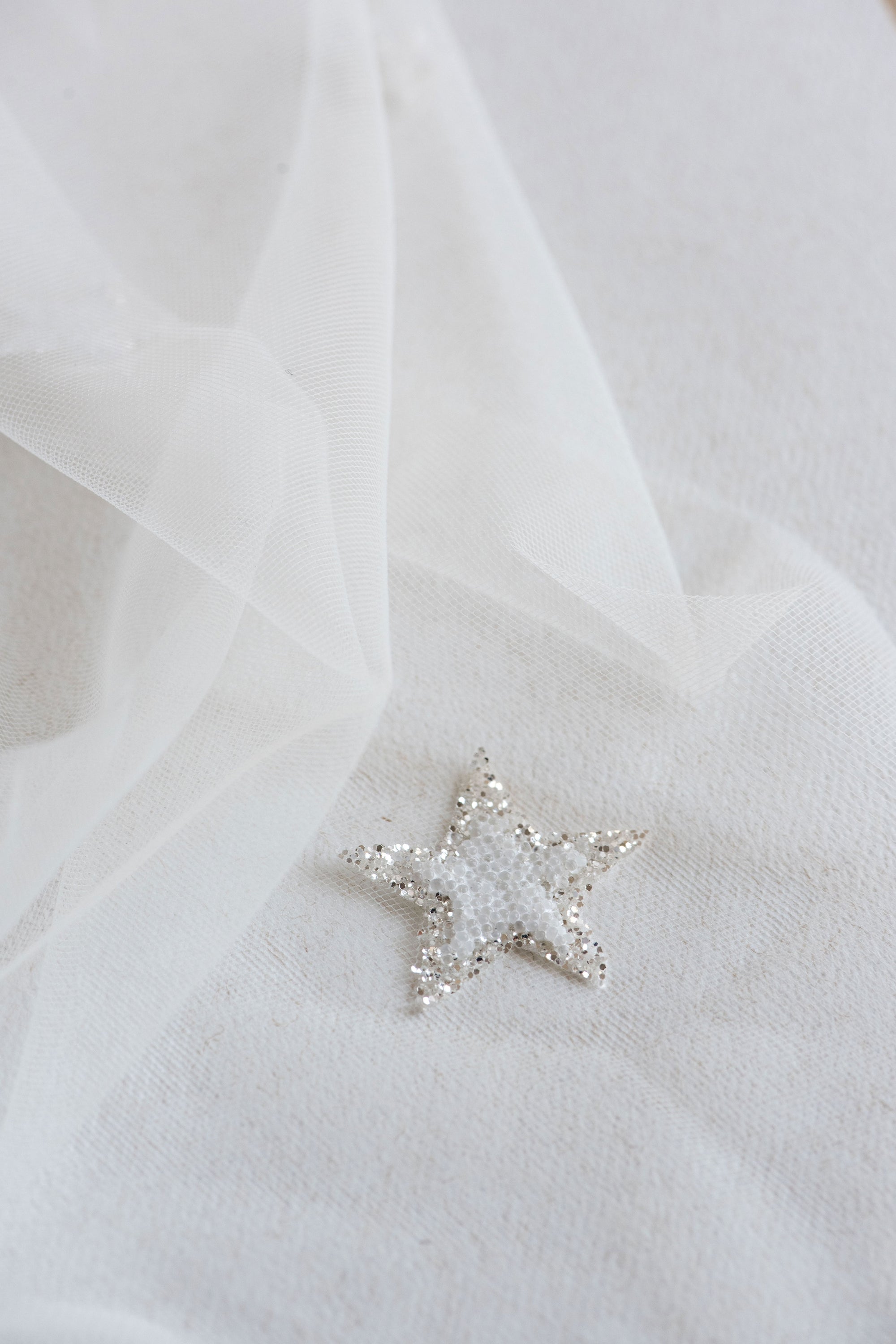 Close-up of beaded star appliqués with silver glitter on Italian tulle – COELESTINE celestial bridal veil