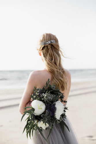 Bride at the beach wearing a silver bridal hair comb, modern boho beach wedding styling, ethereal bridal look