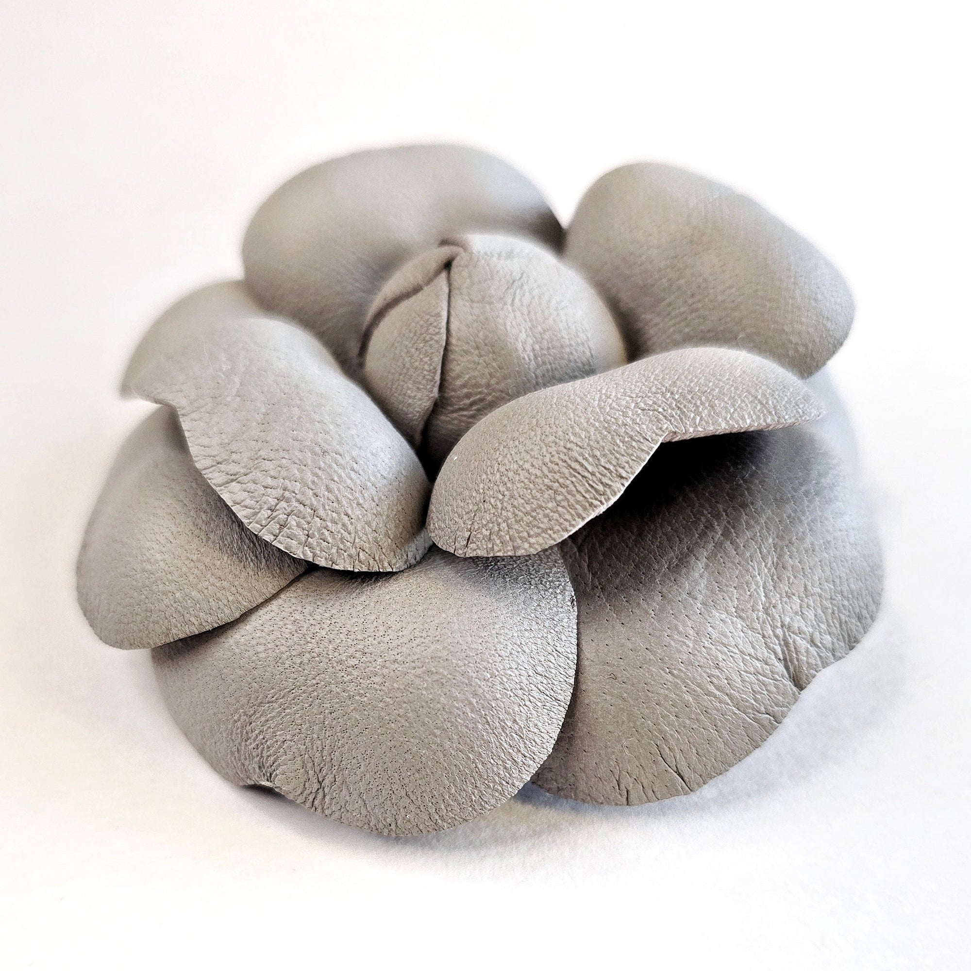 Grey leather camellia brooch with sculptural layered petals and matte finish