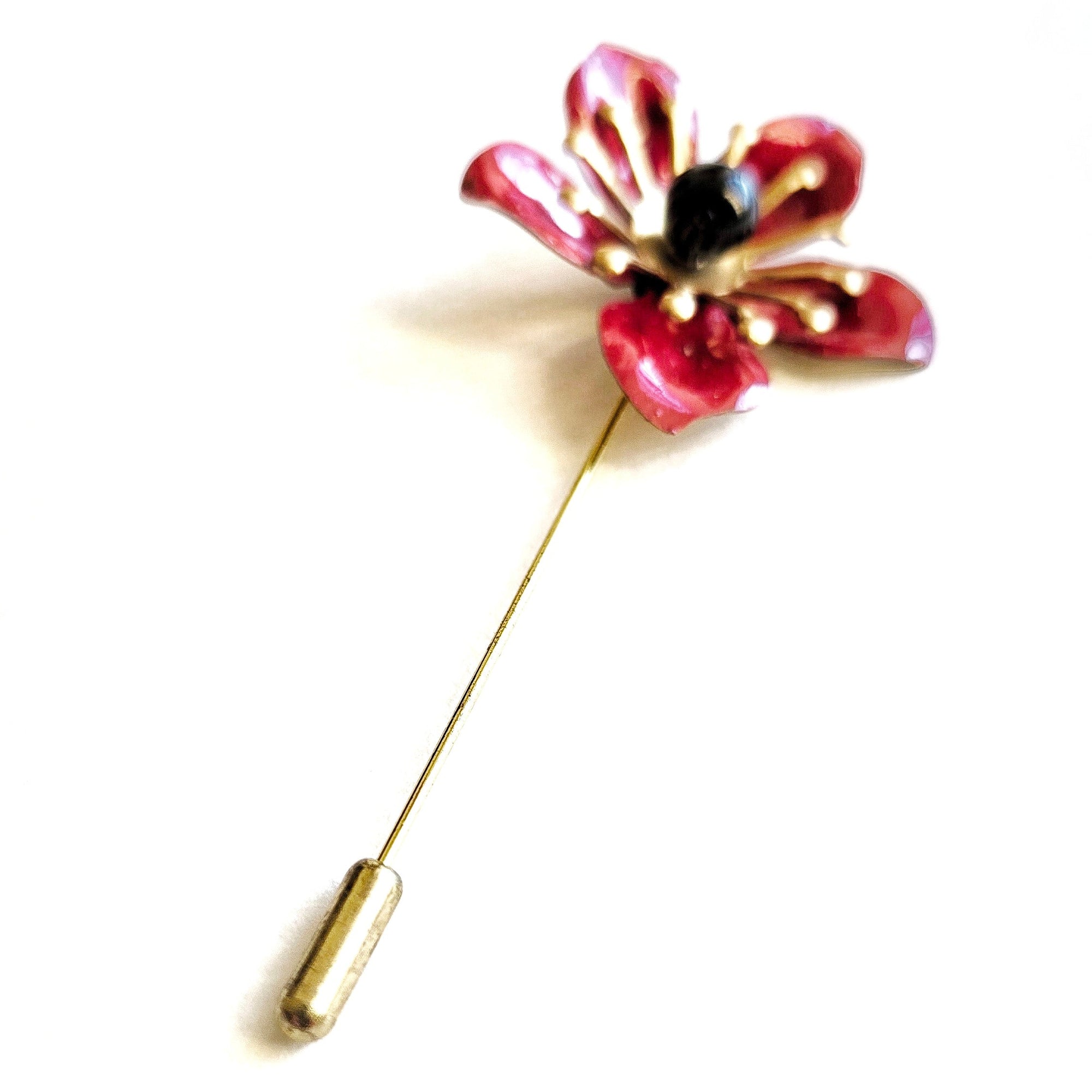 Red flower-shaped brooch on a white background