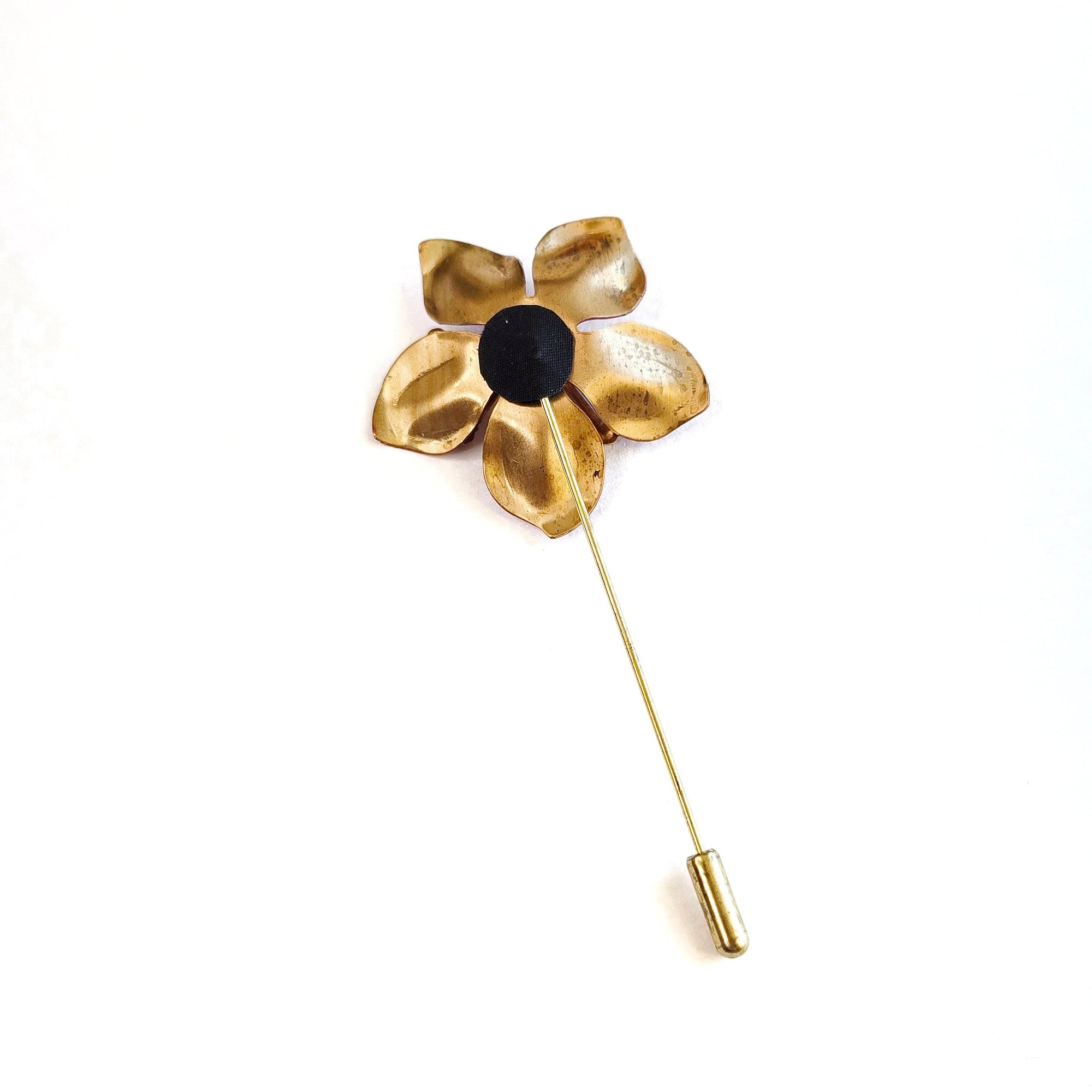 Enamel red poppy lapel pin shown at angle, brass pin backing and sculptural flower form