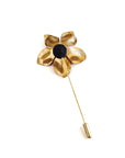 Enamel red poppy lapel pin shown at angle, brass pin backing and sculptural flower form
