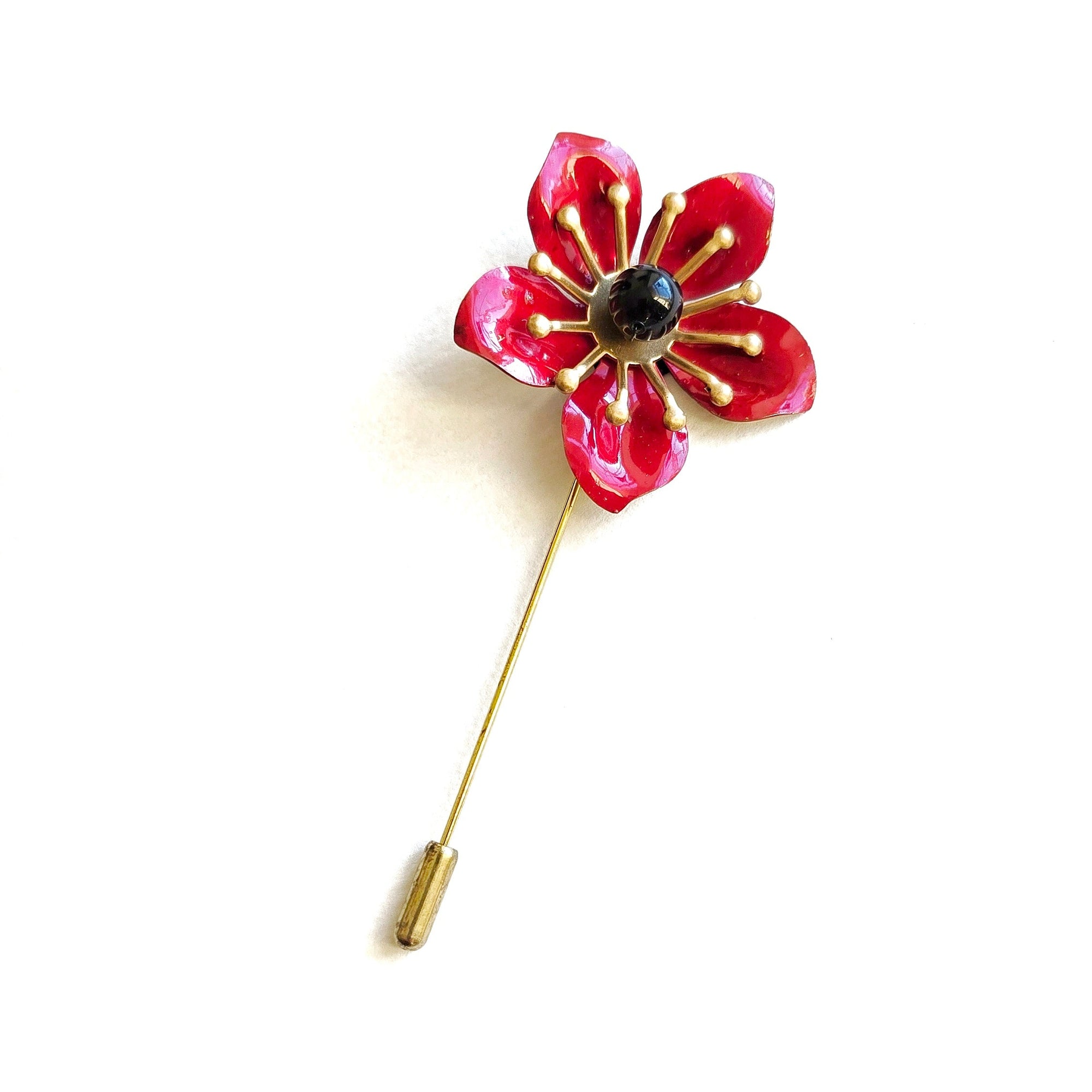 Red poppy lapel pin with enamel petals and black center on brass stem, minimalist floral boutonniere