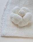 Ivory tweed camellia fabric flower brooch, photographed with the original tweed textile