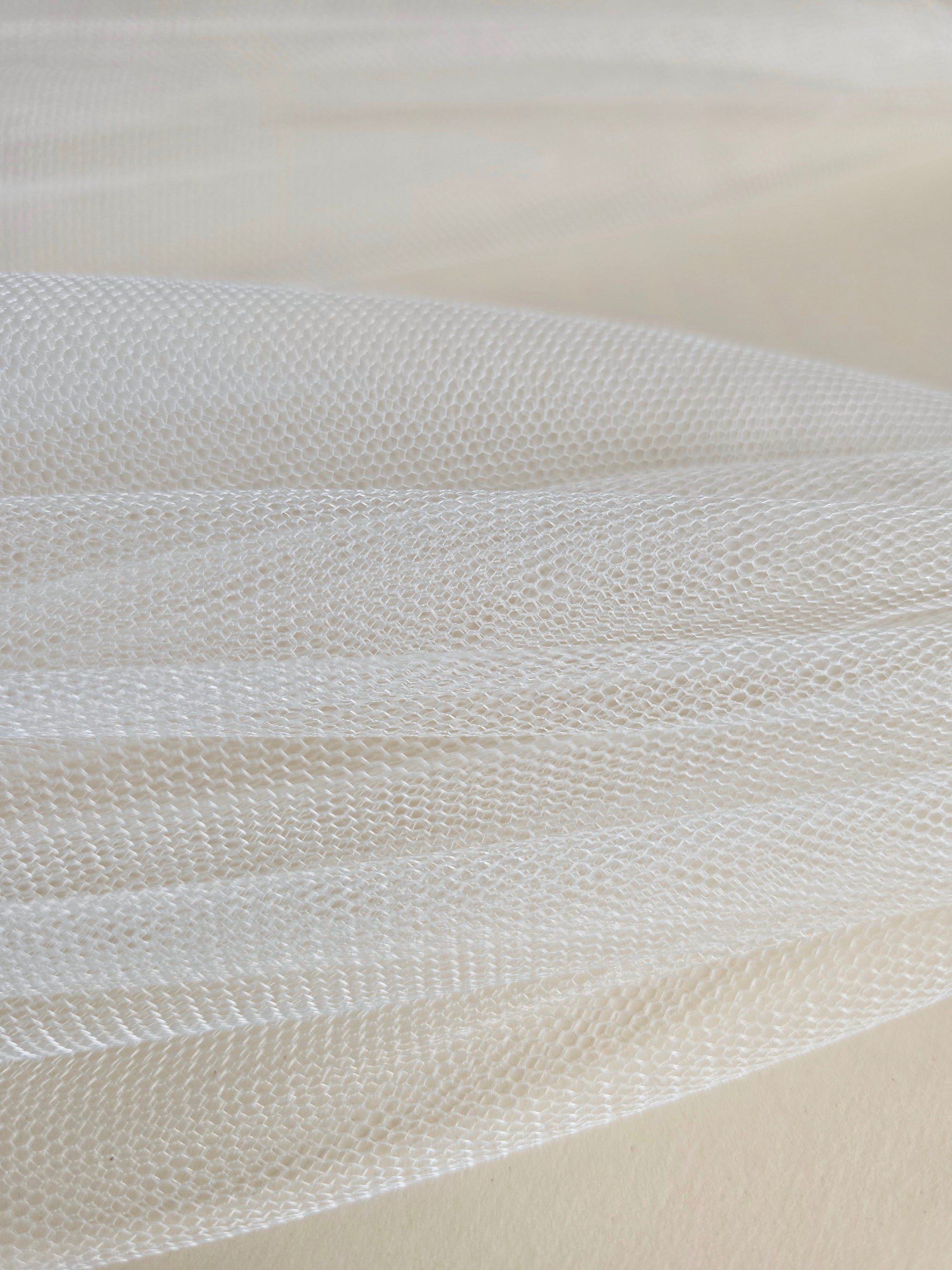 Close-up of soft white English tulle on a beige background