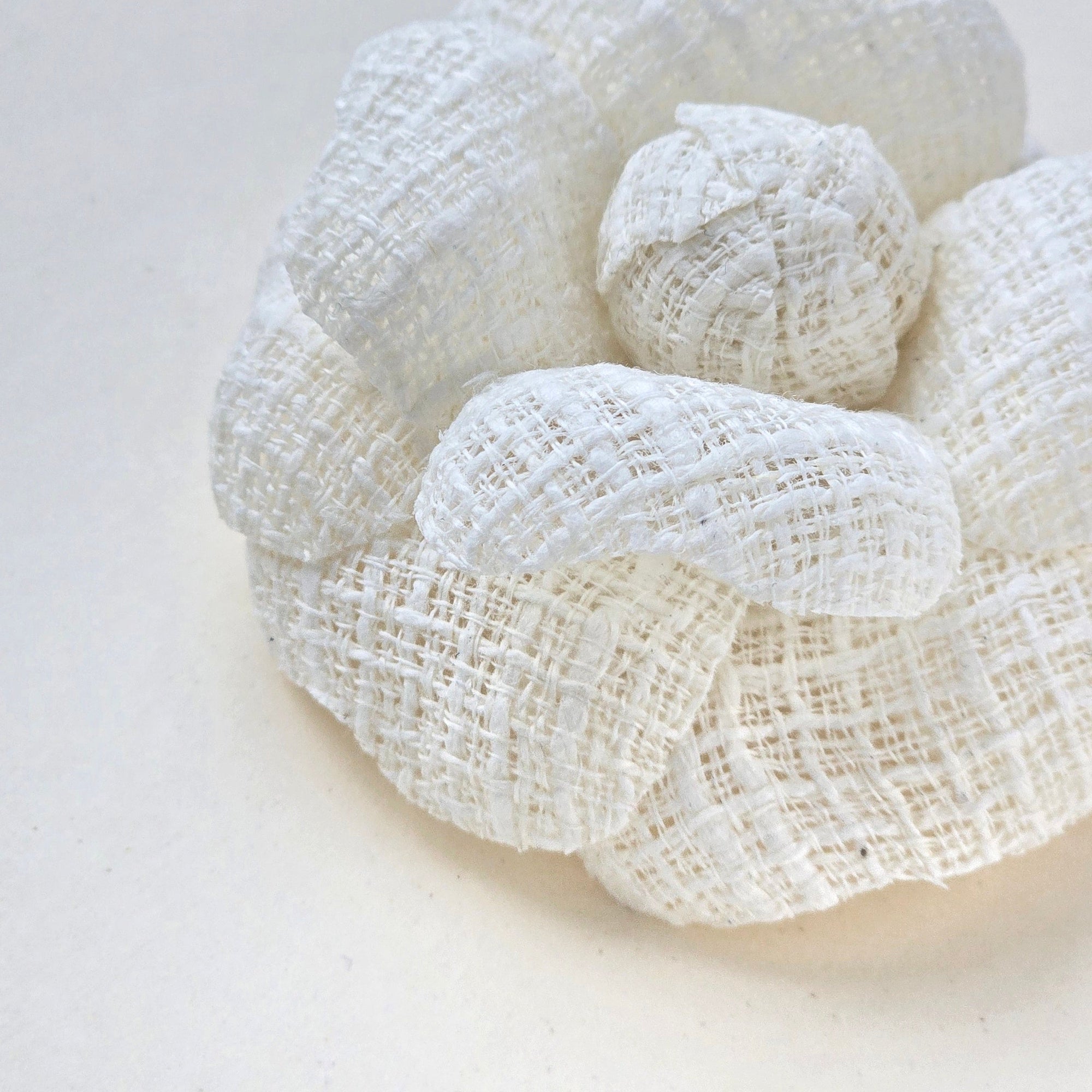 Ivory tweed camellia fabric flower brooch showing texture