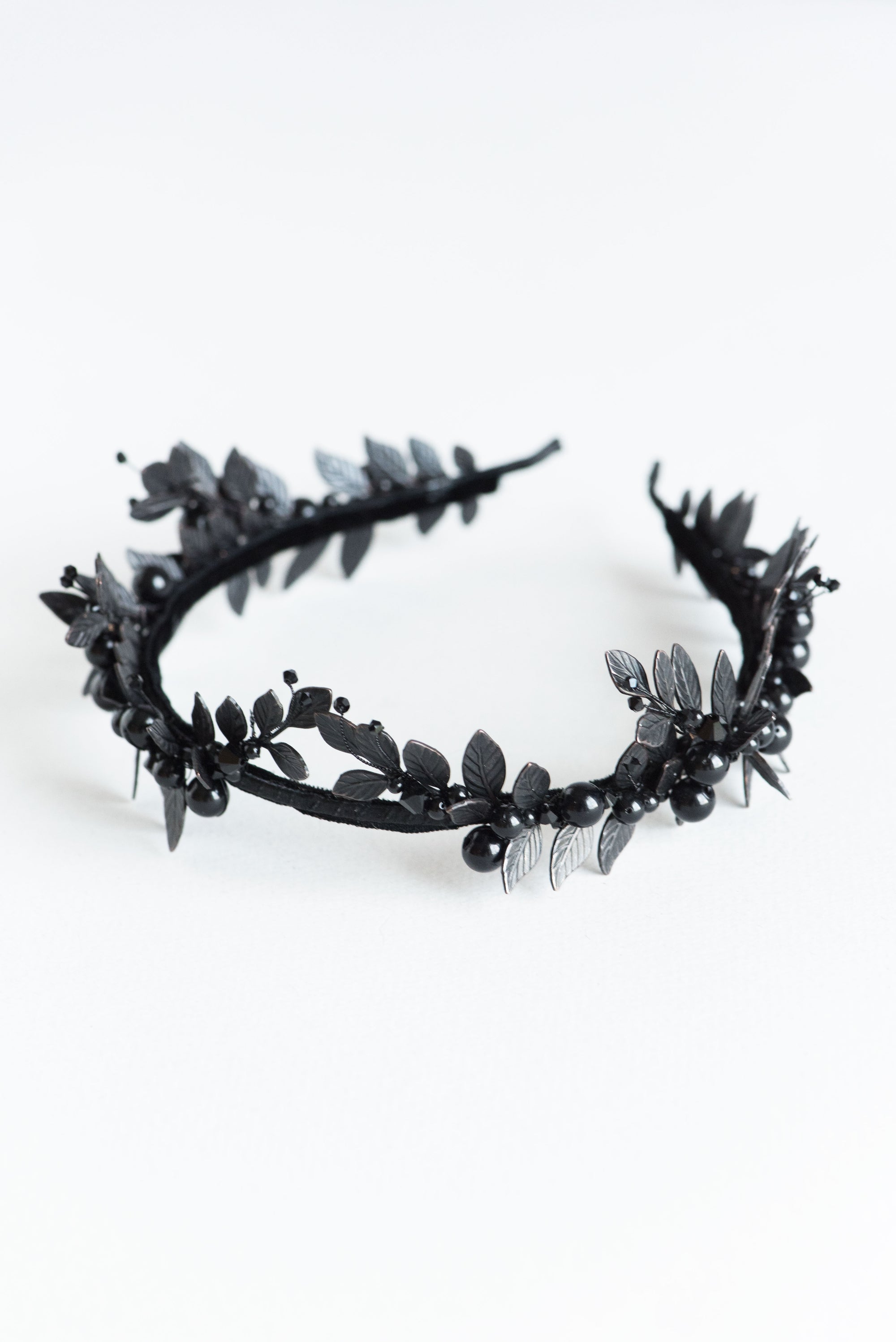 Top view of the LZZY black laurel leaf tiara, showcasing the symmetrical matte black leaf arrangement on a flexible headband.