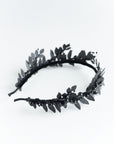 Angled view of the LZZY black headpiece, highlighting the non-reflective matte finish of the brass laurel leaves and pearl accents