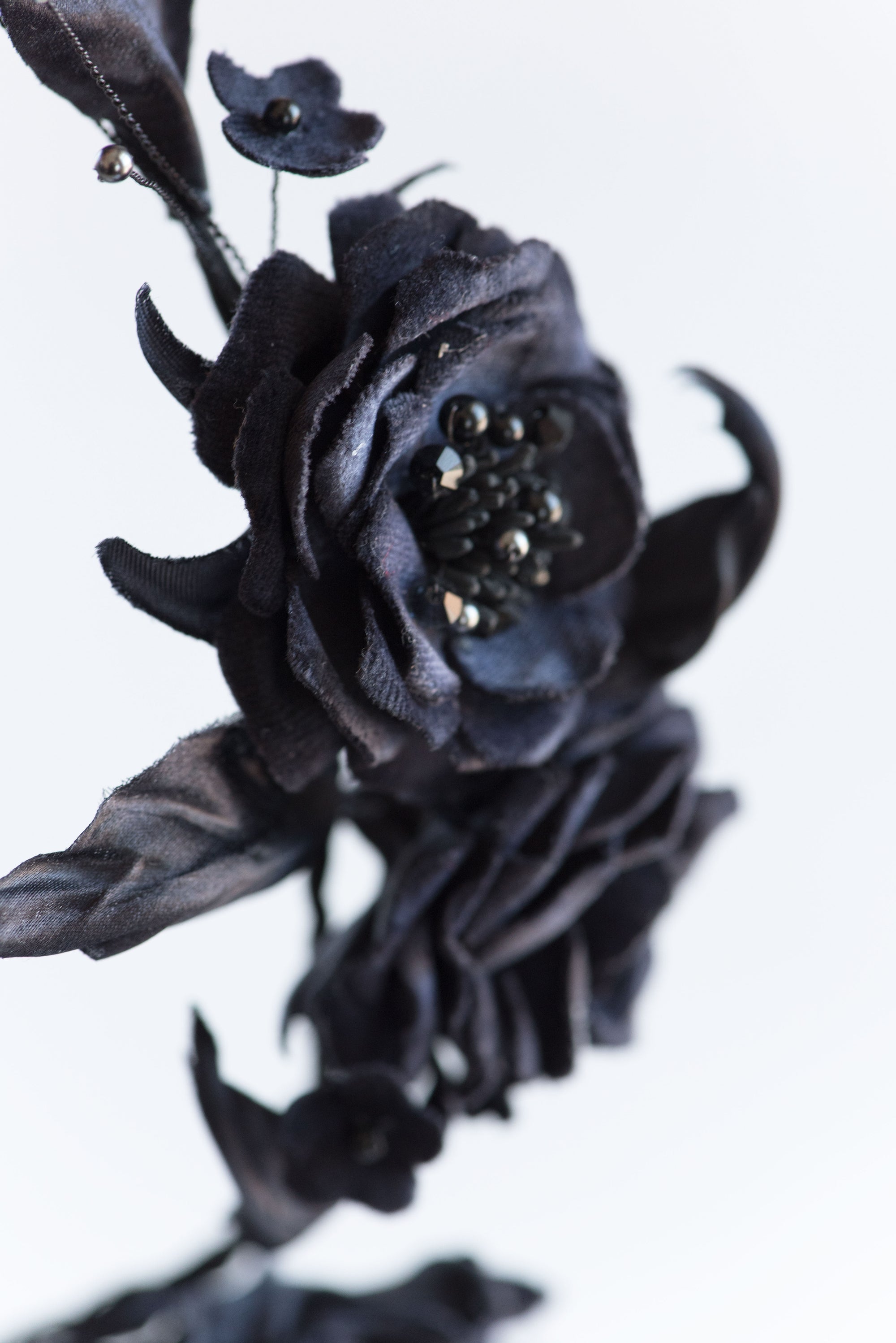 Extreme close-up of FIONA gothic flower crown showing the rich texture of hand-sculpted black silk velvet roses and intricate black crystal stamen centers.
