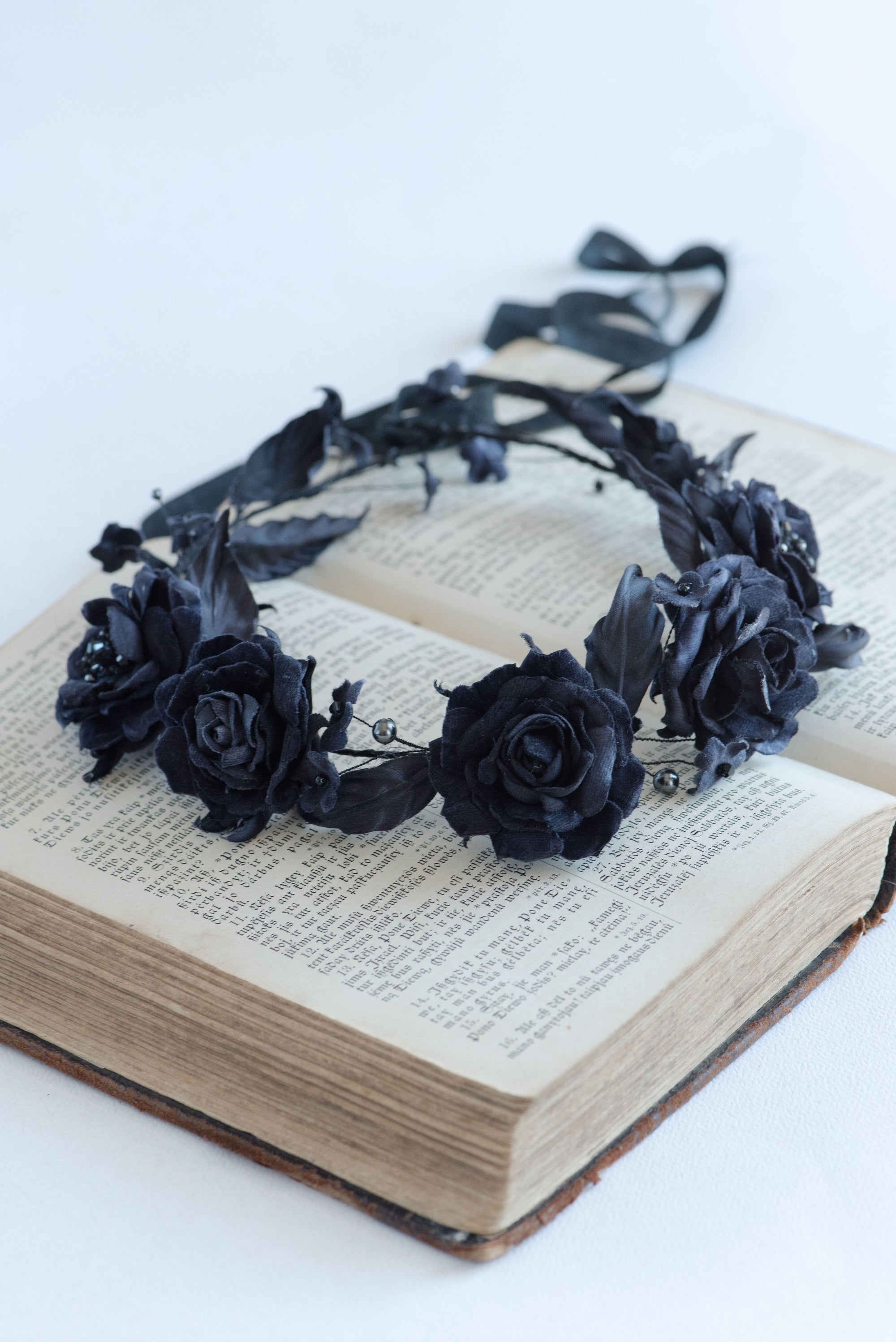 Black floral headband on an open book with a white background