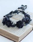 Black floral headband on an open book with a white background