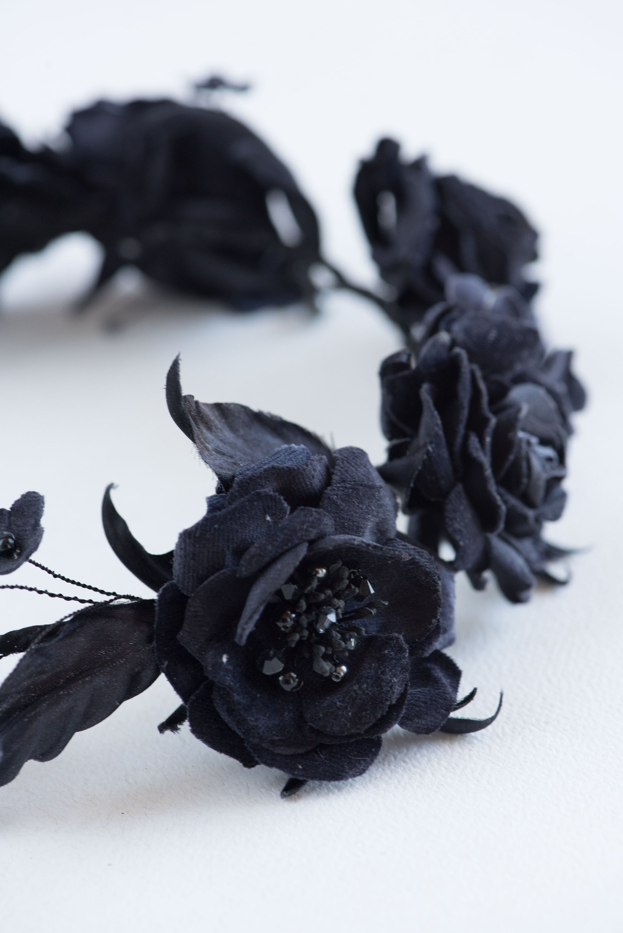 Detailed view of the FIONA black rose tiara, highlighting the fine wirework, hand-shaped silk leaves, and delicate bead accents on a professional couture bridal headpiece.