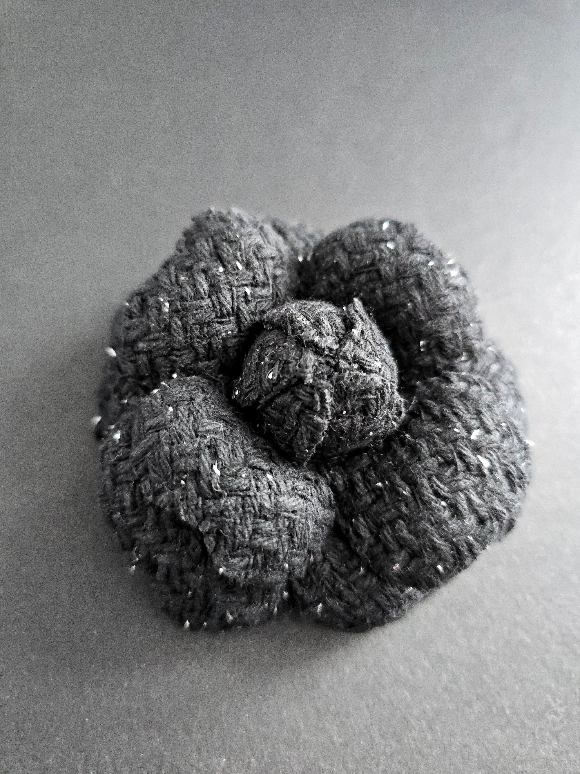 Handmade black tweed camellia brooch with subtle silver sparkles, textured fabric flower pin for blazer or coat