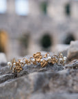 Gold and pearl headband on stone surface with blurred ancient architecture in the background