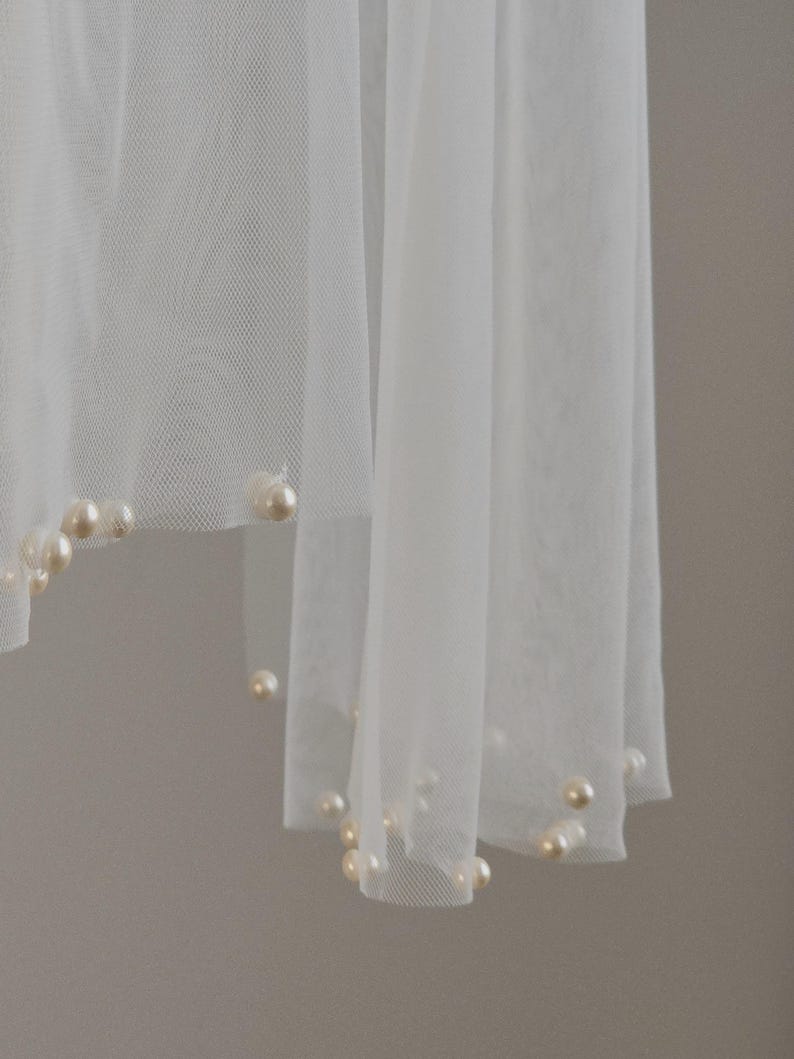 Close-up of hand-applied pearls on soft wedding tulle scarf