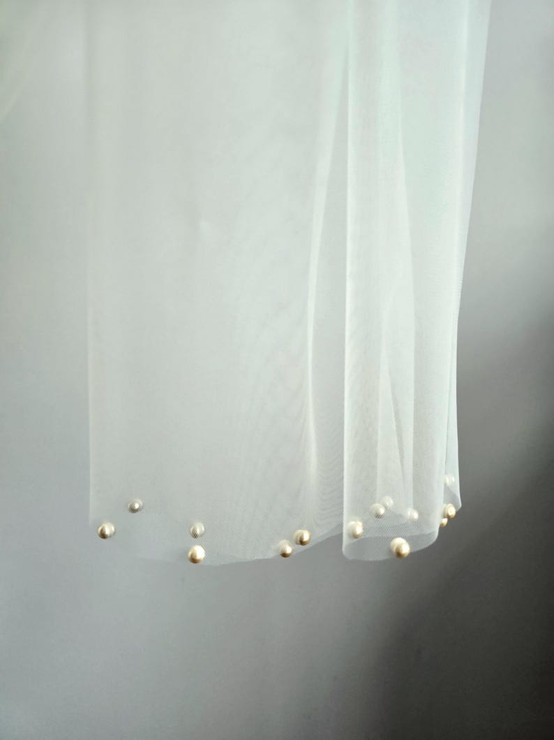 Close-up of hand-applied pearls on soft wedding tulle scarf