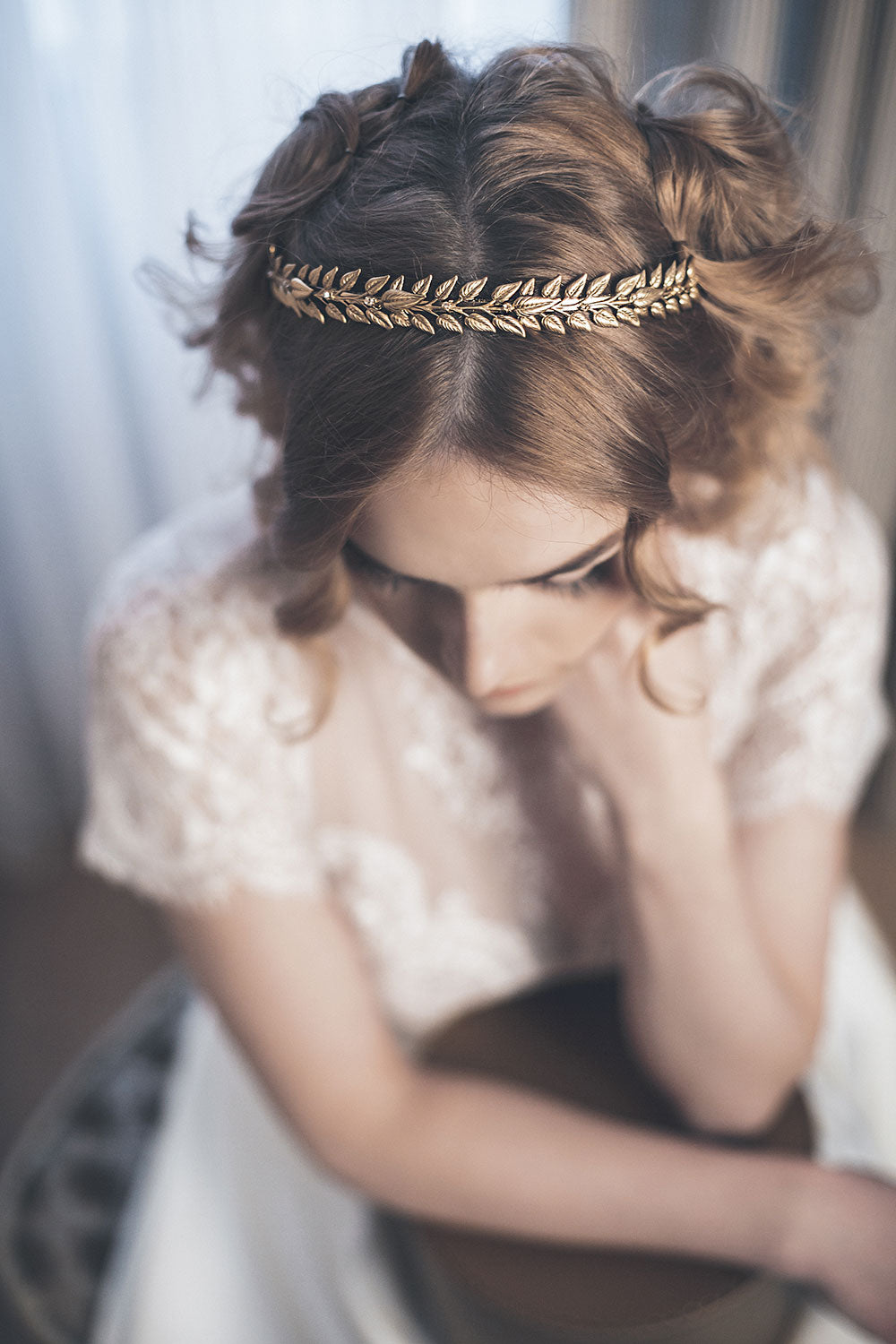 Slim gold laurel headband with small leaves and subtle crystal accents worn in a bridal hairstyle