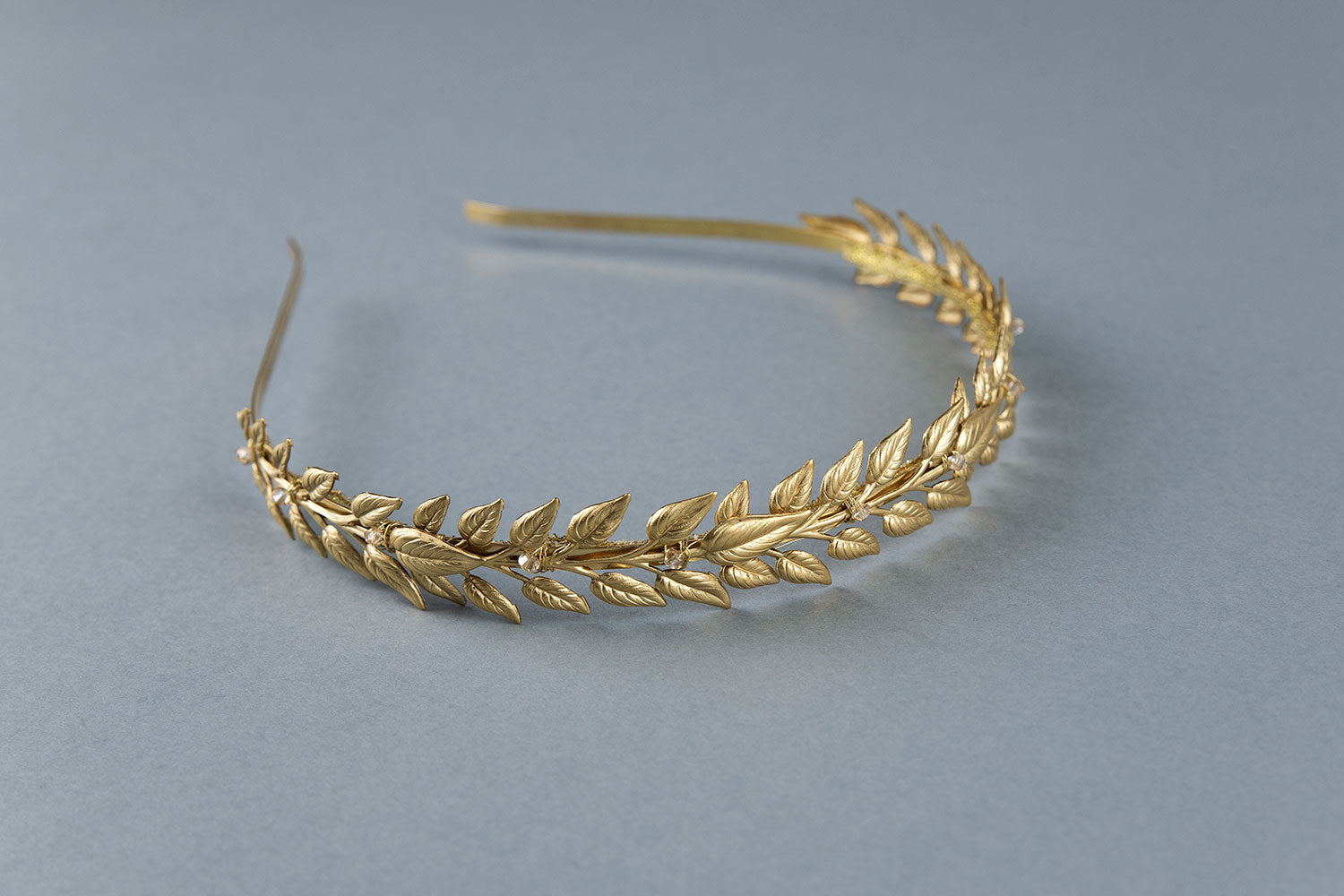 Brass laurel leaves with subtle crystal accents on Alexandra slim gold laurel headband