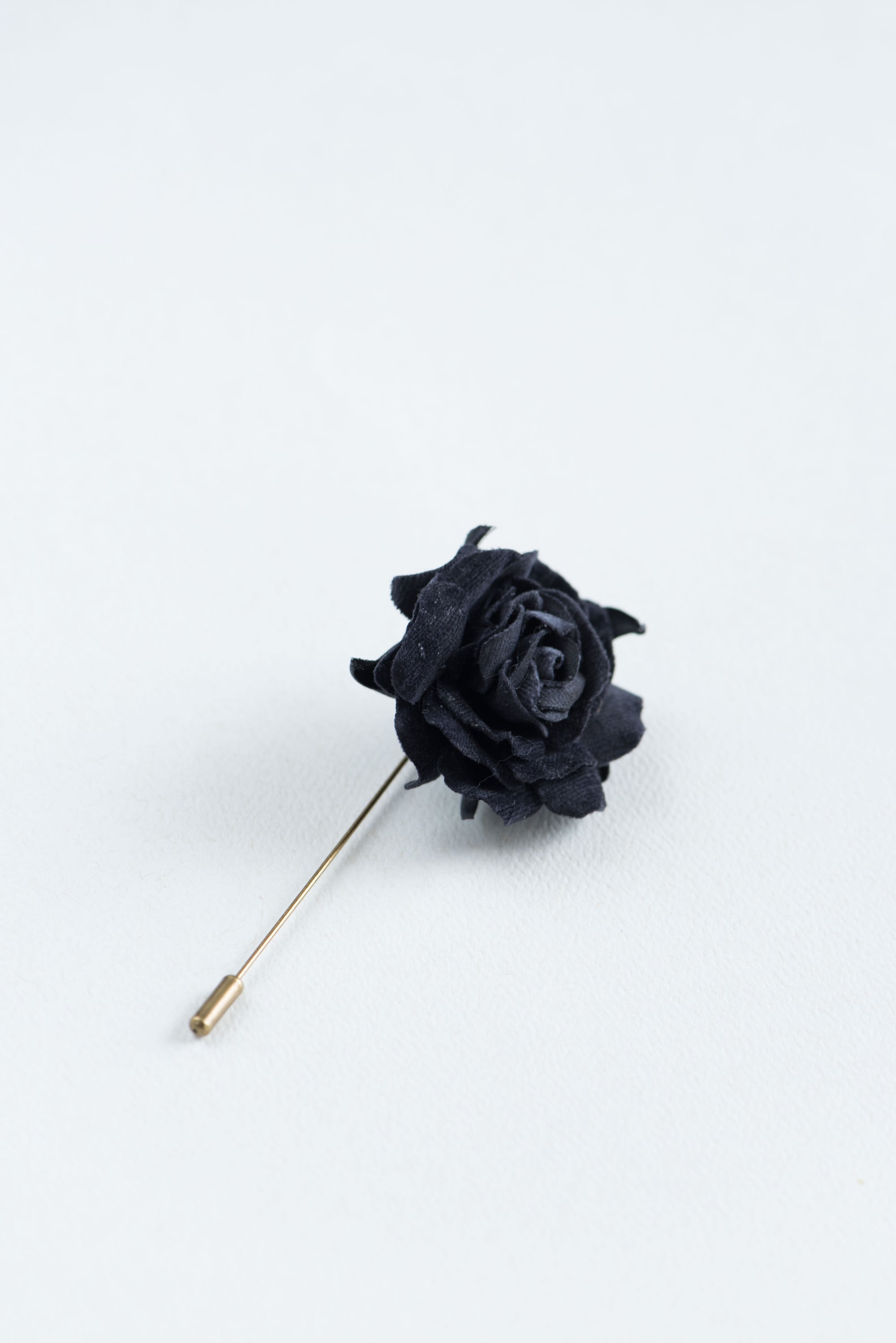 Black rose lapel pin on a white background