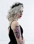 Side view of the LZZY black laurel crown on a white background, showing the matte black leaves and dark pearl accents.
