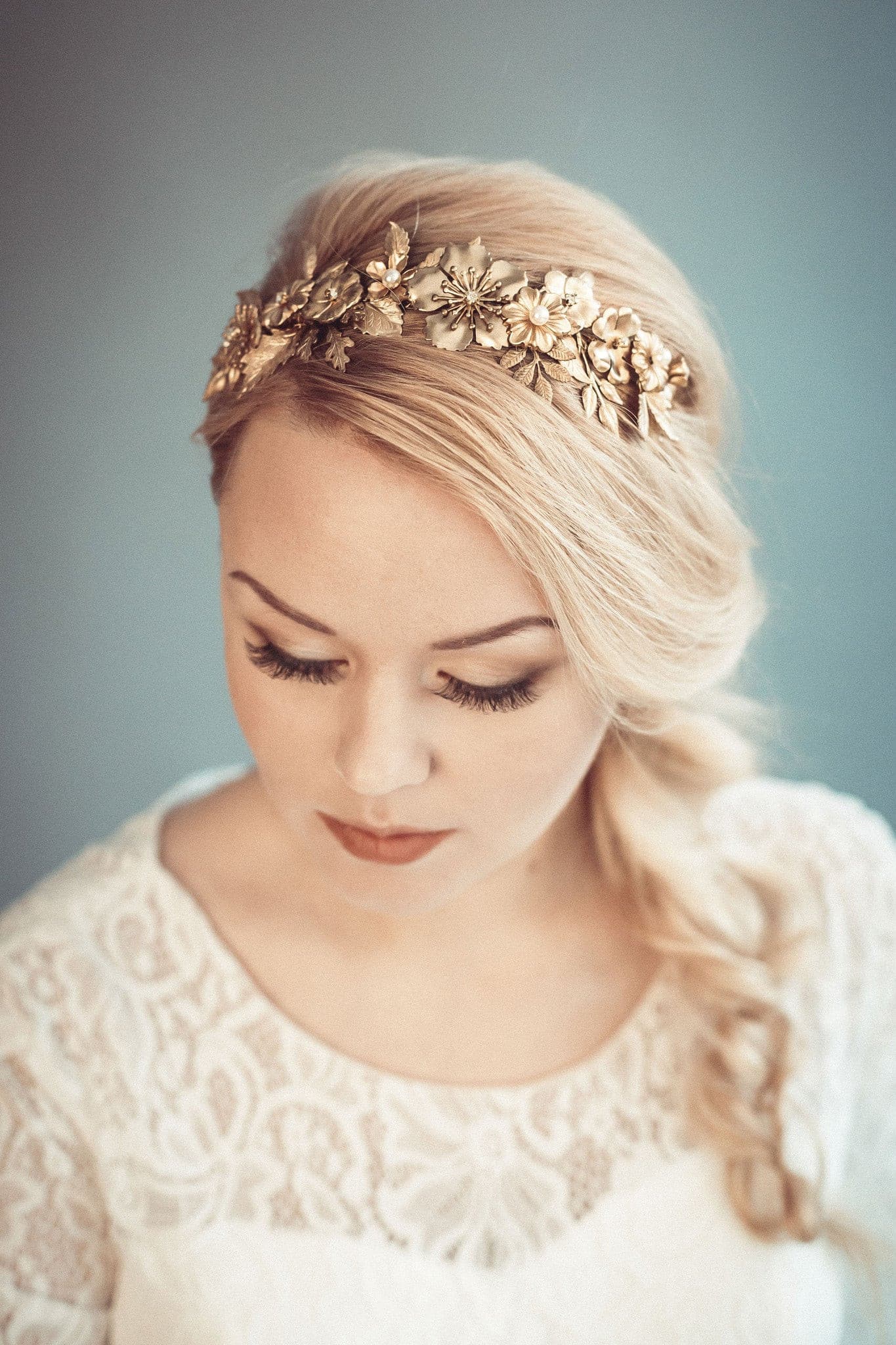 Thalia gold botanical bridal headband featuring dense handcrafted brass leaves and wildflowers with Preciosa pearls, shown on a bride with a blonde side-braid.