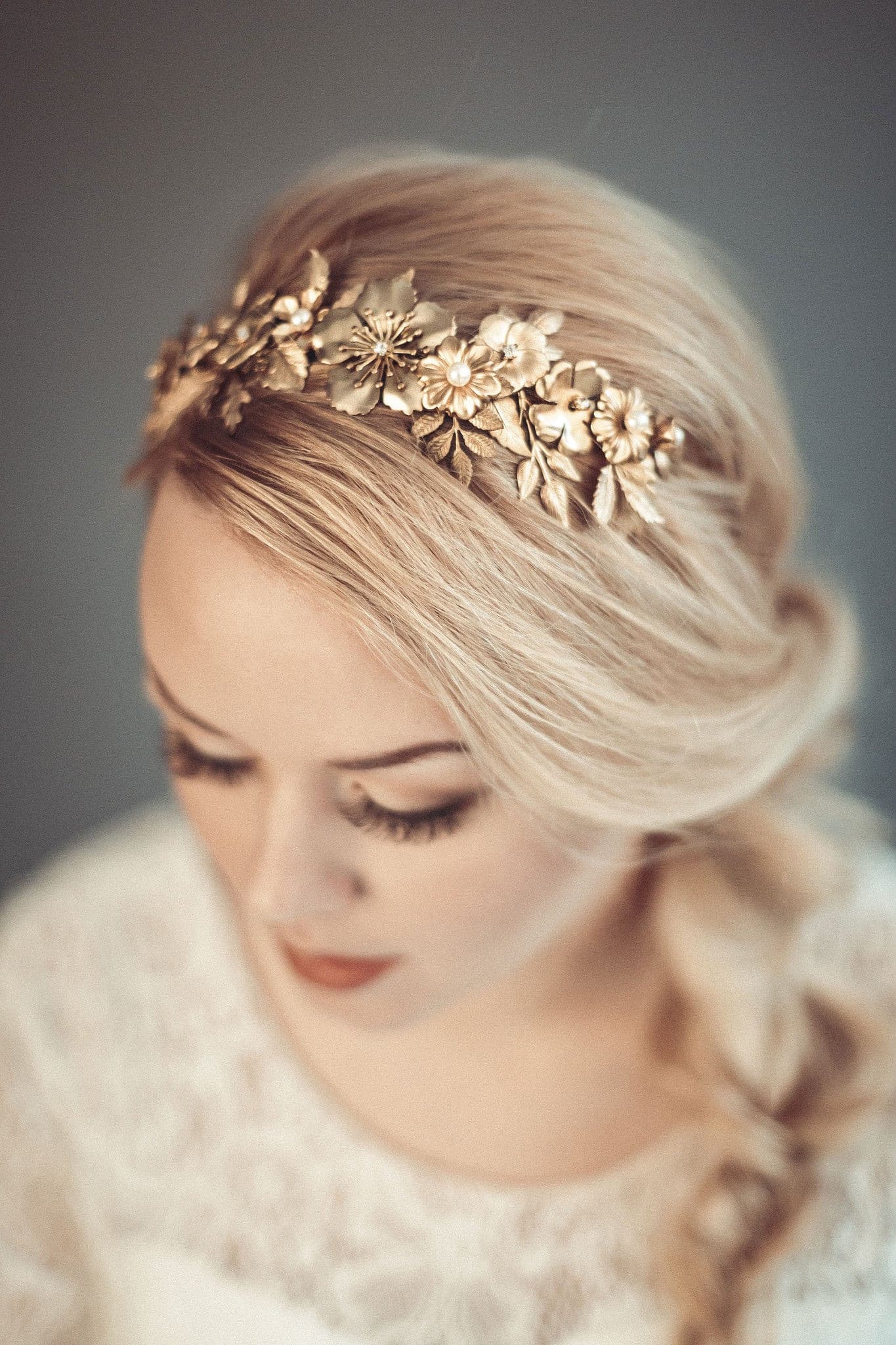 Thalia gold botanical bridal headband featuring dense handcrafted brass leaves and wildflowers with Preciosa pearls, shown on a bride with a blonde side-braid.
