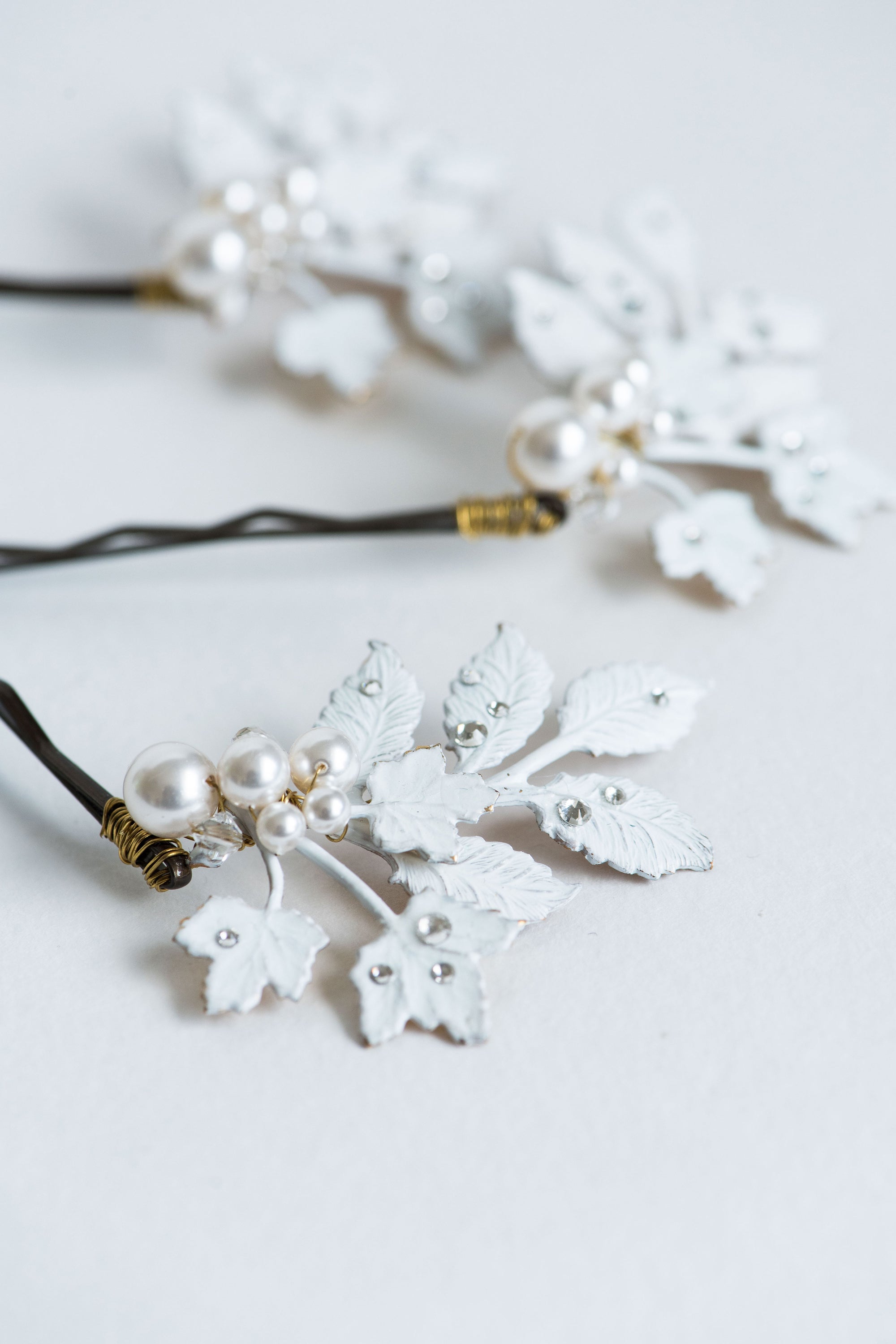 Close-up of frosted leaf bridal hair pin with pearls and rhinestones