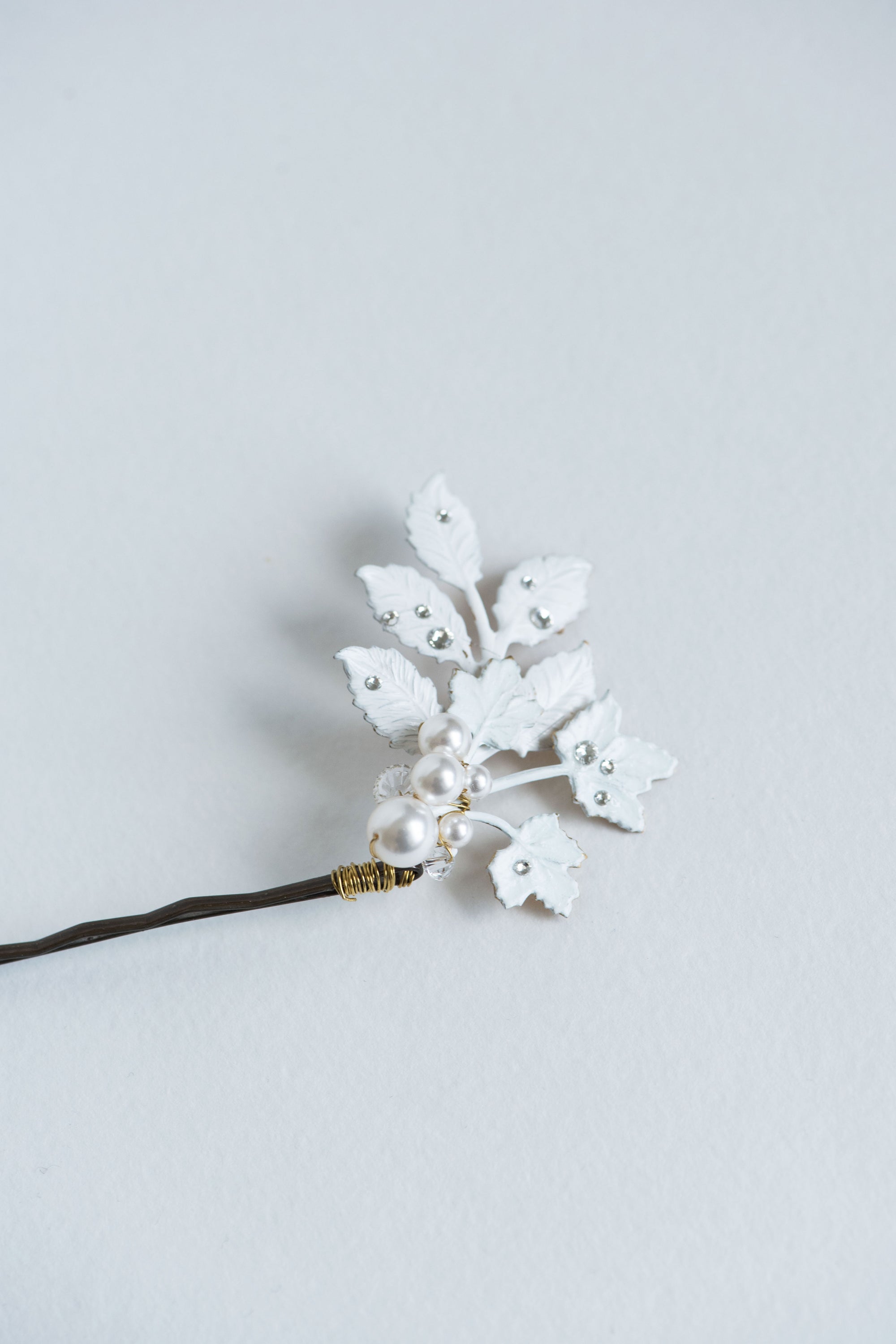 Close-up of frosted leaf bridal hair pin with pearls and rhinestones