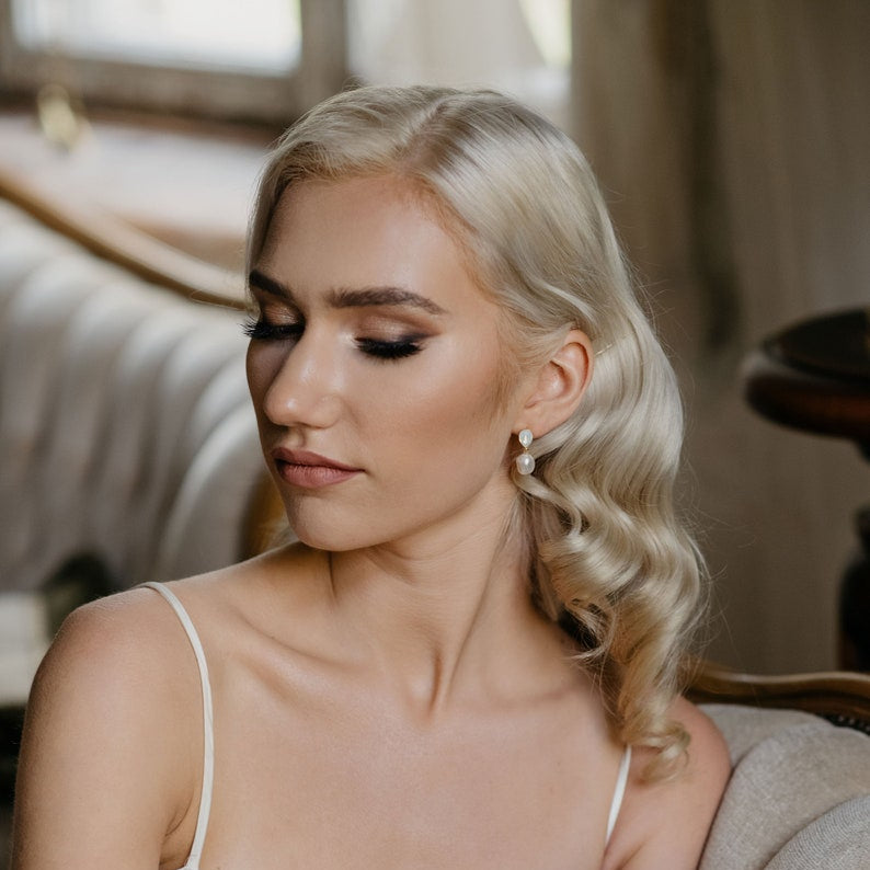 Bride wearing PERELLA baroque pearl drop earrings with white opal crystal accents
