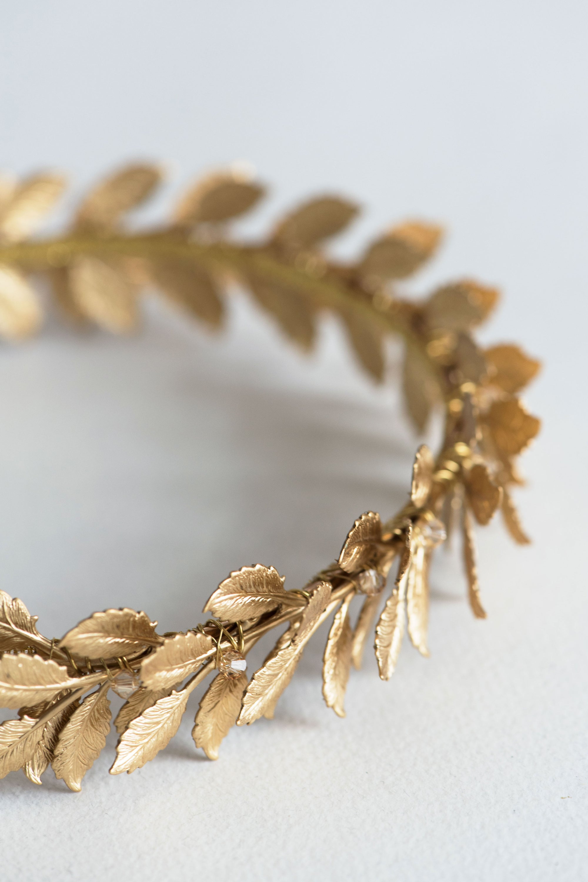 Gold metal laurel leaves with crystal details on a Roman-style bridal headband
