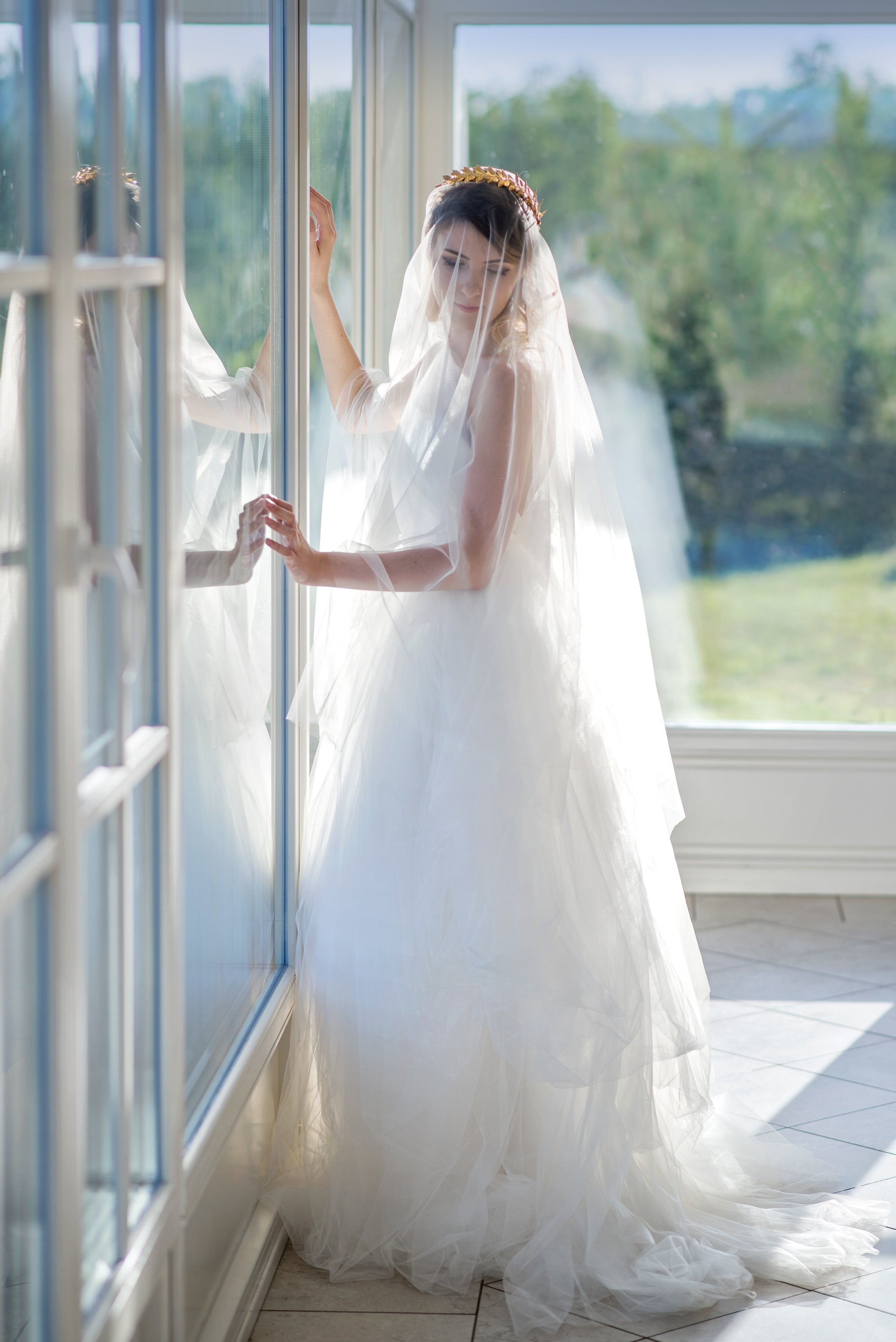 Modern bride wearing CLOTILDE golden laurel bridal headband with wedding veil