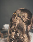 Small gold laurel hair comb worn in bridal hairstyle