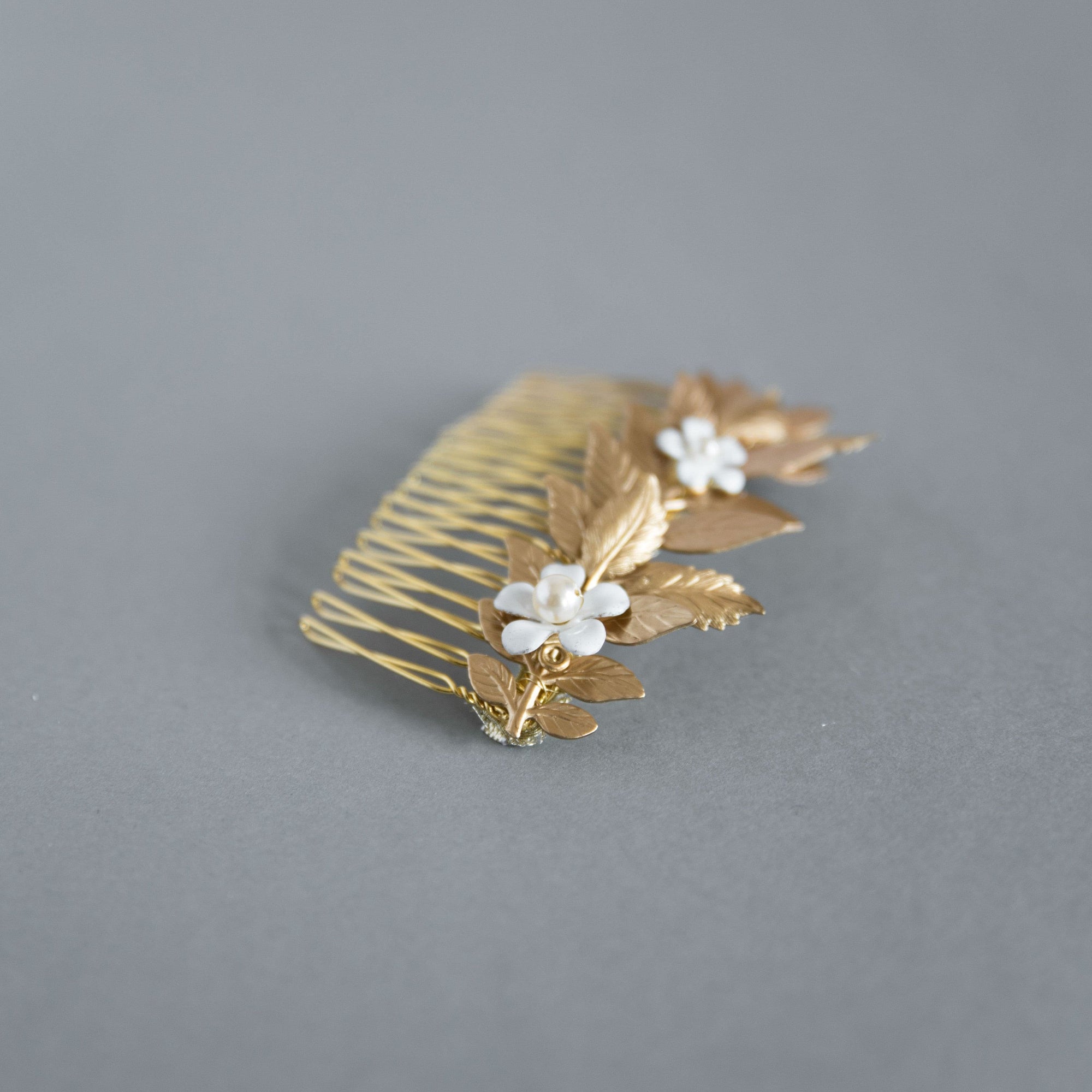 Botanical gold hair comb with leaf and enamel flower design